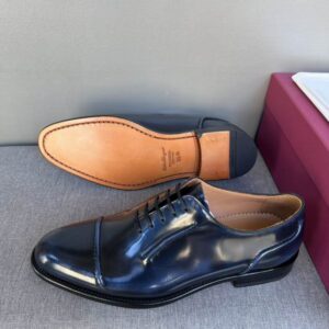 Top-down view of navy blue leather Oxford shoes in a red designer box, showing the cap-toe detail and the tan leather "Tramezza" branded interior.