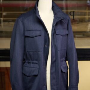A navy blue field-style technical jacket featuring four front patch pockets, a stand collar, and a hidden interior down-filled liner.