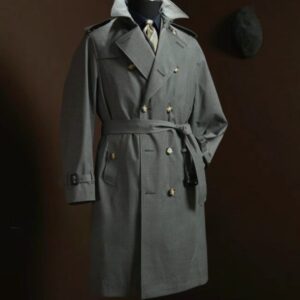 A long-length, double-breasted trench coat in navy Italian wool featuring a waterproof finish, shoulder epaulets, a belted waist, and a structured silhouette.