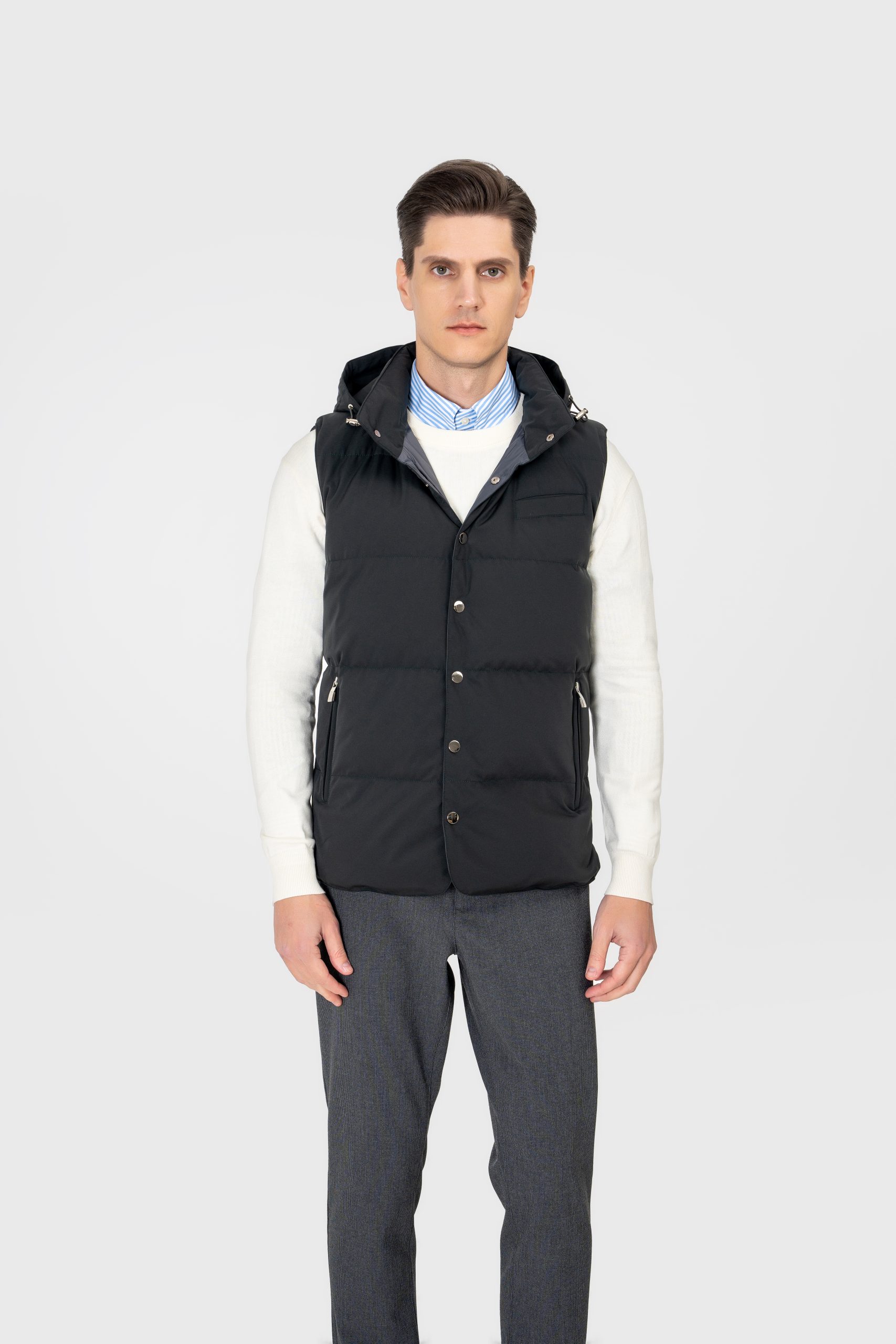 A horizontal quilted down vest with a stand collar and removable hood, featuring snap-button fasteners, chest pockets, and double rear vents.
