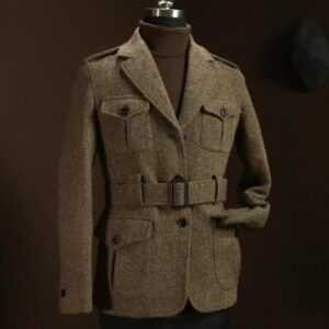 A women’s belted safari jacket in textured tweed wool featuring four front patch pockets, shoulder epaulets, and a classic notch lapel.