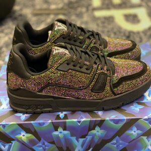 Side view of Louis Vuitton LV Trainer Black Strass sneakers covered in multicolour crystals, resting on a blue Monogram patterned box.