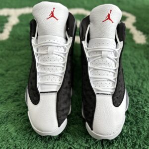 view of Air Jordan 13 Retro Black Flint Grey sneakers featuring black mesh, grey suede, white leather toes, and the iconic green holographic eye