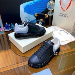 Profile view of Alexander McQueen Black and White Gradient Oversized Sneakers showing the ombre leather upper and thick black platform sole.