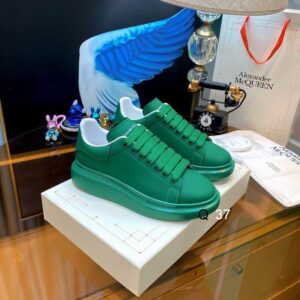 Profile view of monochromatic Alexander McQueen Green Leather Oversized Sneakers featuring an emerald leather upper and matching thick platform sole.