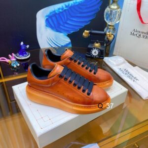 Side view of Alexander McQueen Tan Leather Oversized Sneakers featuring black laces and a chunky tan rubber sole.