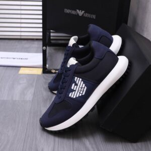 A pair of Armani Navy Blue shoes featuring a white eagle logo and chunky white midsole on a grey wooden surface.