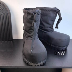 Side view of black quilted Balenciaga Alaska snow boots with a chunky rubber sole and drawstring top.