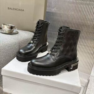 Side profile of black matte leather Balenciaga Bulldozer boots featuring a massive 80mm platform and silver logo-embossed metal plates on the sole.