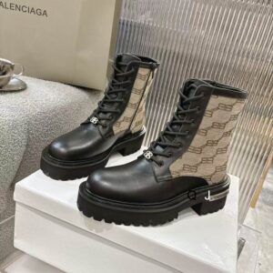 Side view of Balenciaga Strike boots featuring black leather toes and beige BB monogram canvas shafts with a thick lug sole.