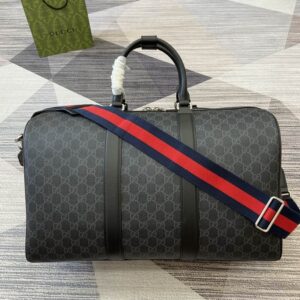 Side view of a Gucci Black Travel Duffle featuring GG Supreme canvas and a red and blue webbed strap.