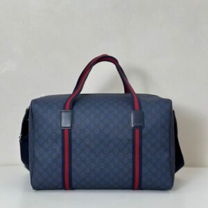 A side view of the Gucci Blue GG Monogram Duffle Bag with red and blue Web straps, sized 47 x 30 x 27 cm.