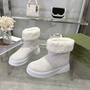 A pair of Gucci White Monogram Fur-Trimmed Boots featuring a white GG pattern and fluffy fur collar