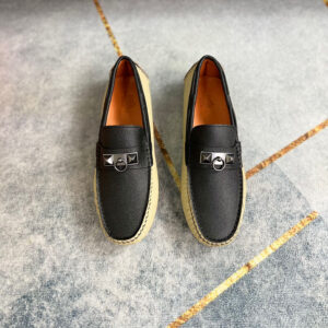 Hermes Beige Black Textured Loafers featuring two-tone leather and matte black hardware on a grey floor.