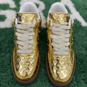 LV X NIKE AIR FORCE 1 Low Monogram Patent Gold Brown sneaker, showing the reflective gold patent leather, brown midsole, black outsole, and debossed Monogram pattern.