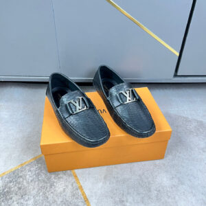 Louis Vuitton Black Embossed Leather Statement Loafers shown with textured leather upper, metallic emblem detail, slip on design, and structured sole