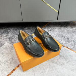 A pair of Louis Vuitton Black Grained Leather Loafers shoes featuring gold-tone hardware and a pebbled finish.