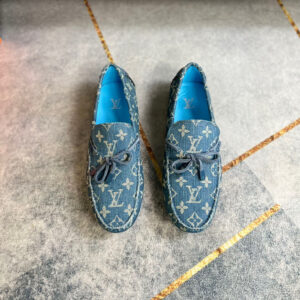 Pair of Louis Vuitton Blue Denim Monogram Loafers featuring turquoise lining on a grey floor
