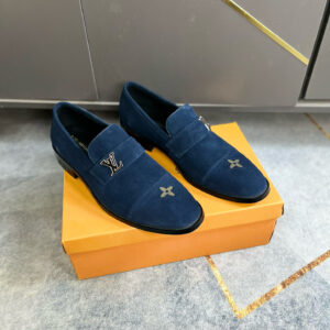 Pair of navy blue Louis Vuitton suede loafers with silver LV logo on the strap and embroidered flower on the toe.