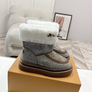 A pair of Louis Vuitton Bronze Rhinestone Boots featuring bronze crystals, monogram patterns, and white fur trim.