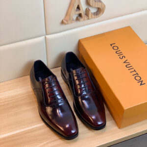 Louis Vuitton Burnished Burgundy Brogue Shoes featuring a deep black cherry gradient and wingtip perforations on a wooden display.