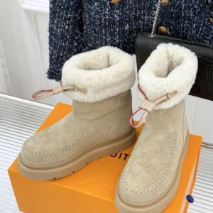 A pair of Louis Vuitton Grey Suede Monogram Boots in grey suede with embossed patterns and grey fur trim.