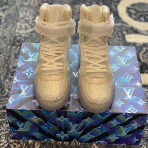 White, translucent high-top trainers made of iridescent vinyl with a clear sole and Velcro ankle strap, resembling the Louis Vuitton Trainer Boot.