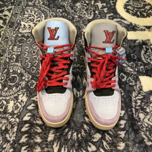 Pair of a Louis Vuitton LV 408 high-top sneaker showing the lavender suede, turquoise accents, and bright red laces with blue lace lock detail.