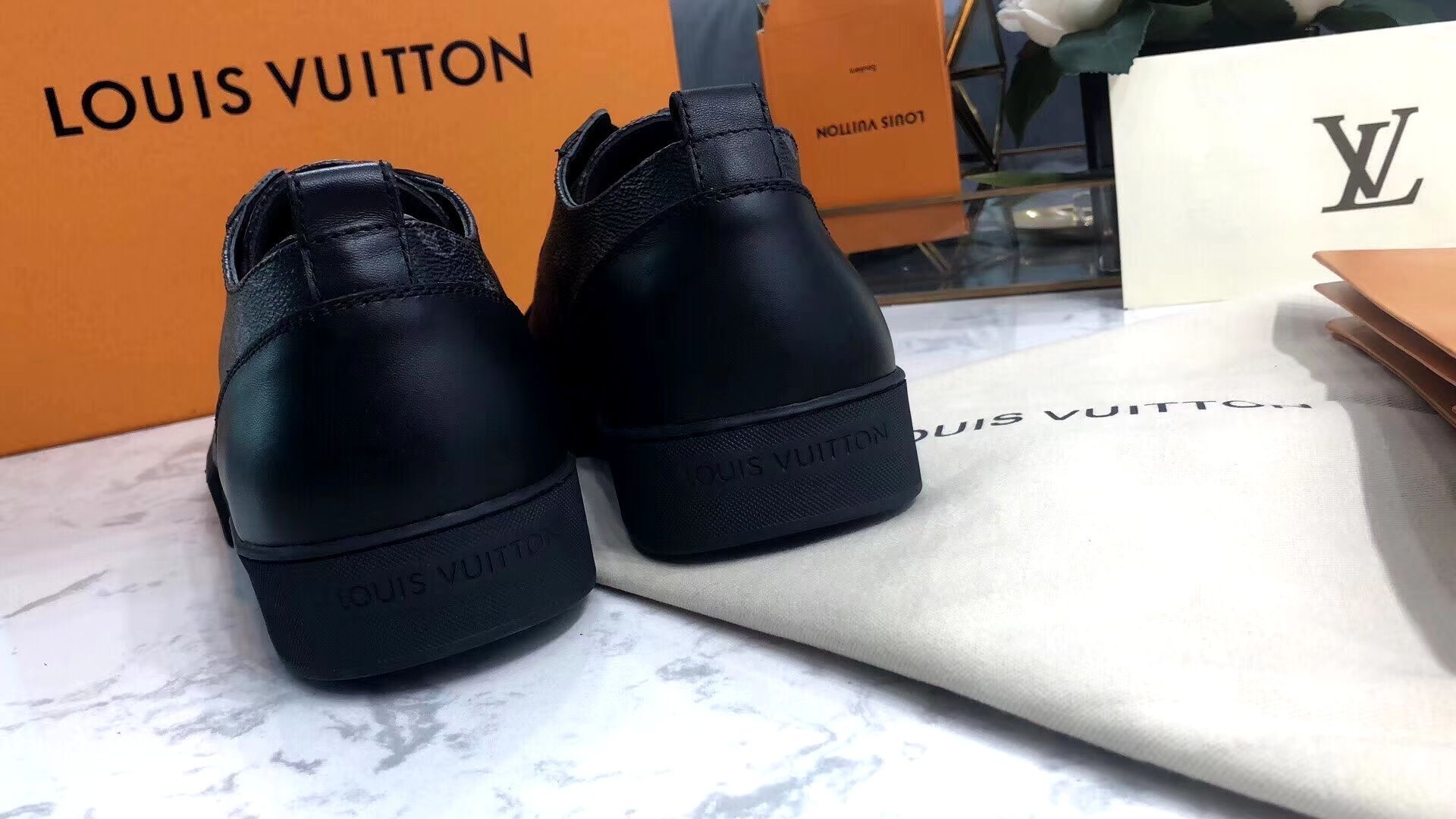Rear and side view of the Louis Vuitton Match-Up Sneaker in black monogram showing the leather heel tabs and the LV signature canvas side panels.