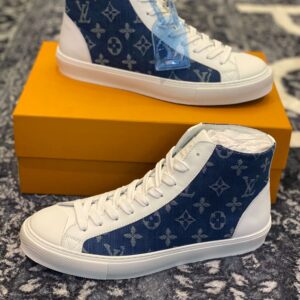 Side view of Louis Vuitton Stellar High Top sneakers in blue monogram denim with white laces and a thick white rubber sole.
