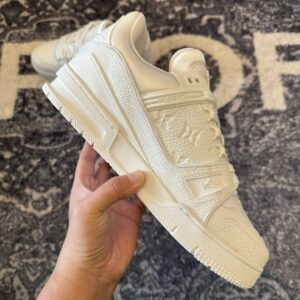 Side-by-side view of two Louis Vuitton Trainer Triple White Swarovski sneakers showing the all-white crystal overlays.