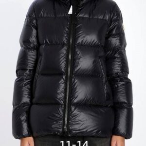 A woman wearing the Moncler Black Glossy Puffer Jacket featuring a high-shine finish and a protective hood.