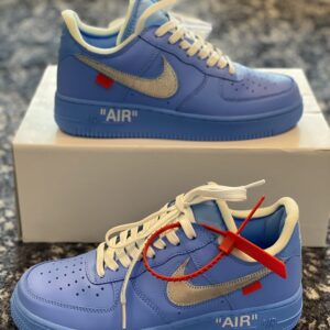 Side view of the Off-White x Nike Air Force 1 Low MCA University Blue sneaker featuring a metallic silver Swoosh and red zip-tie.