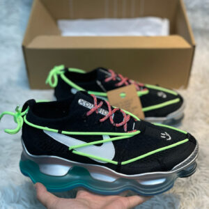 A pair of Nike Black Neon CPFM Air Flea 2 Shoes with neon green cords, silver midsoles, and smiley face embroidery on a textured grey background.