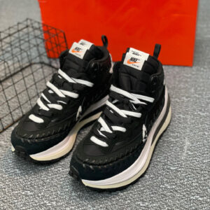 Side view of Nike Black White Sacai Shoes featuring a high-top black upper with a chunky stacked white midsole.