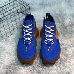 A pair of Nike Royal Blue Orange Air Max Flyknit Shoes featuring a blue knit upper and a thick orange translucent Air Max sole on a white textured background.