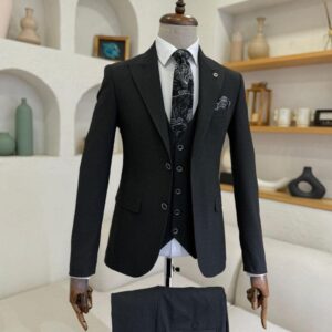 A man's Sartorial Charcoal Grey Three-Piece Suit displayed on a mannequin with a white shirt and patterned tie.