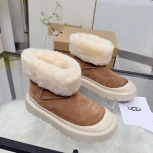 A pair of UGG Chestnut Platform Boots featuring tan suede and white fur collars on a glass table.