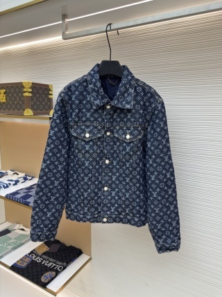 Premium dark blue Louis Vuitton Monogram Denim Jacket featuring the iconic LV monogram pattern throughout. Classic trucker-style denim jacket with branded silver buttons hanging in a high-end boutique display.