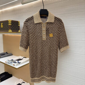 A close-up of a Louis Vuitton Brown Knit Polo with a diamond crochet pattern and beige collar hanging in a boutique.