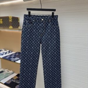 Premium dark blue Louis Vuitton Monogram Denim Pants with an all-over LV monogram pattern hanging on a black hanger. Close-up of luxury-inspired straight-leg denim jeans featuring branded silver hardware in a boutique setting.