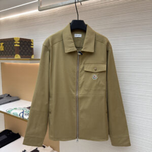 A Moncler Khaki Zip Overshirt with a chest pocket logo hanging in a high-end fashion boutique.