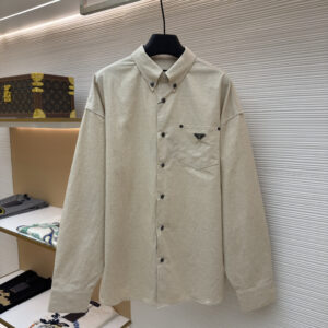 A premium Prada Beige Canvas Shirt featuring an oversized fit and the iconic enameled metal triangle logo on the chest pocket