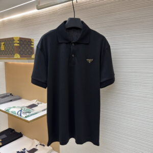 A front-facing view of the Prada Black Pique Polo hanging in a luxury boutique setting.