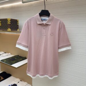 Front view of a pastel pink Prada layered polo shirt with contrast white trims hanging on a boutique display rack.