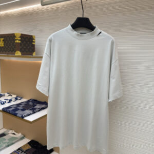 A men's Balenciaga white oversized washed cotton t-shirt with a red tape logo on the back hanging on a clothes rail.