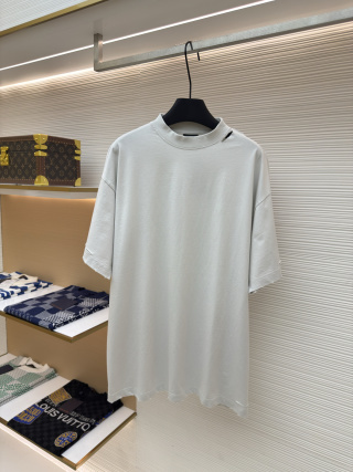 A men's Balenciaga white oversized washed cotton t-shirt with a red tape logo on the back hanging on a clothes rail.