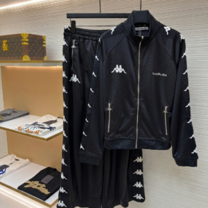 A coordinated Acne Studios x Kappa Tracksuit Set featuring the logo-taped jacket and wide-leg trousers on display hangers.