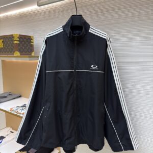 A black Balenciaga oversized track jacket with white stripes and a back logo hanging in a boutique.