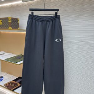 Dark grey wide-leg Balenciaga sweatpants with an elastic waistband and a small white Unity logo on the front left leg.